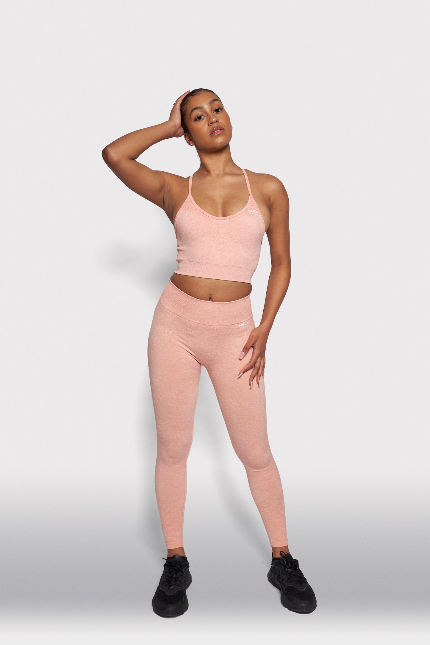 girl in peach coloured bra top and leggings gymwear set